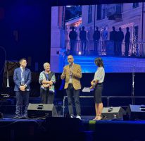 La foto rappresenta il Presidente Robaldo che porta il saluto della Provincia sul palco allestito in Piazza Galimberti per gli 80 anni di Confartigianato Il Presidente Luca Robaldo agli 80 anni di Confartigianato