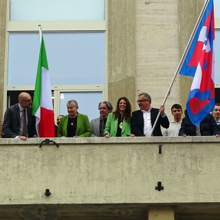 L'apposizione delle bandiere sulla facciata della manica storica di corso Giolitti