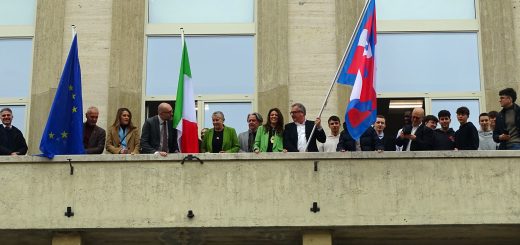 L'apposizione delle bandiere sulla facciata della manica storica di corso Giolitti