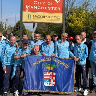 I giocatori dell'Over 50 Football Club Provincia Granda con la bandiera della Provincia per le strade di Manchester
