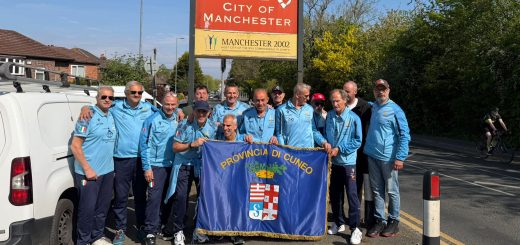 I giocatori dell'Over 50 Football Club Provincia Granda con la bandiera della Provincia per le strade di Manchester
