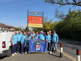I giocatori dell'Over 50 Football Club Provincia Granda con la bandiera della Provincia per le strade di Manchester